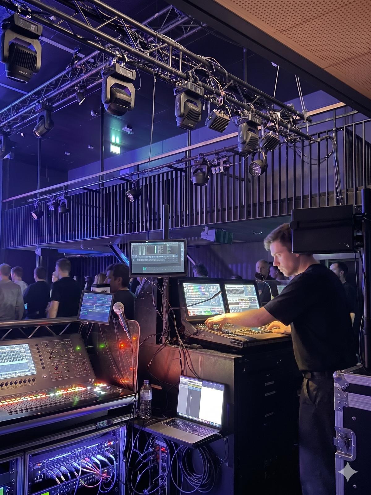 Tech crew working at lighting and audio control desk during live production